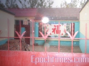 Здесь расположена пекинская «чёрная тюрьма». На стене крупный иероглиф означающий «счастье». Фото: Великая Эпоха