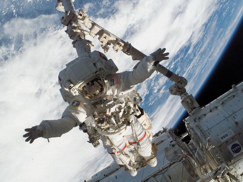 Поставленный на космический якорь Canadarm2, астронавт Rick Linnehan участвует в первом запланированном выходе в открытый космос. Во время семичасового выхода в открытый космос Linnehan подготовил к установке японский модуль “Кибо”. Фото: С сайта nasa.gov
