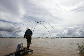 Женщина ловит рыбу в Такхеке в Лаосе. Фото: Hoang Dinh Nam/AFP/Getty Images