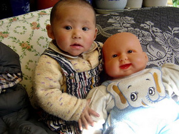 Маленький ребенок с китайской куклой, 2009 художника Kelsang Tsering (1969 г.р.) По традиции в Тибете нет специальных игрушек и кукл для детей. Кукла младенец сделана в Китае и, очевидно, предназначалась для западного рынка. (Келсанг Тзеринг) Фото: Великая Эпоха (The Epoch Times, Германия) 