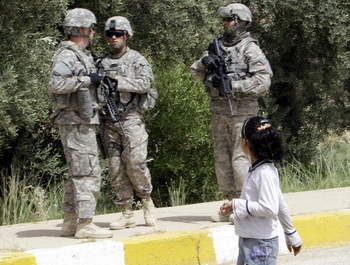 Девочка мирно прогуливается мимо солдат в Ираке. Фото: ALI AL-SAADI/AFP/Getty Images