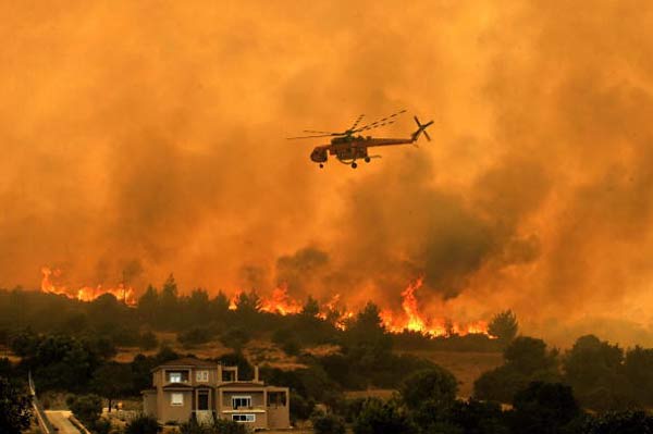 Греция. Горят предместья Афин. Фото: LOUISA GOULIAMAKI, ARIS MESSINIS/AFP/Getty Images