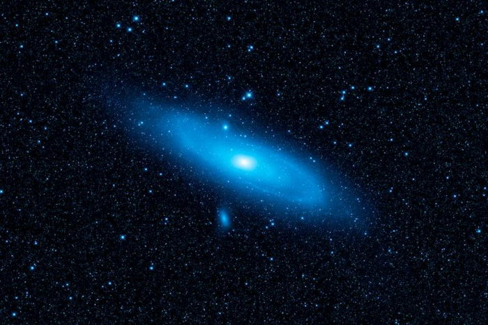 На это изображении телескопа Wide-field Infrared Survey Explorer (дословно: наблюдатель в инфракрасном поле с широким обзором) выделено синим цветом старшее звёздное «население» галактики Андромеды. Фото: NASA/JPL-Caltech/WISE