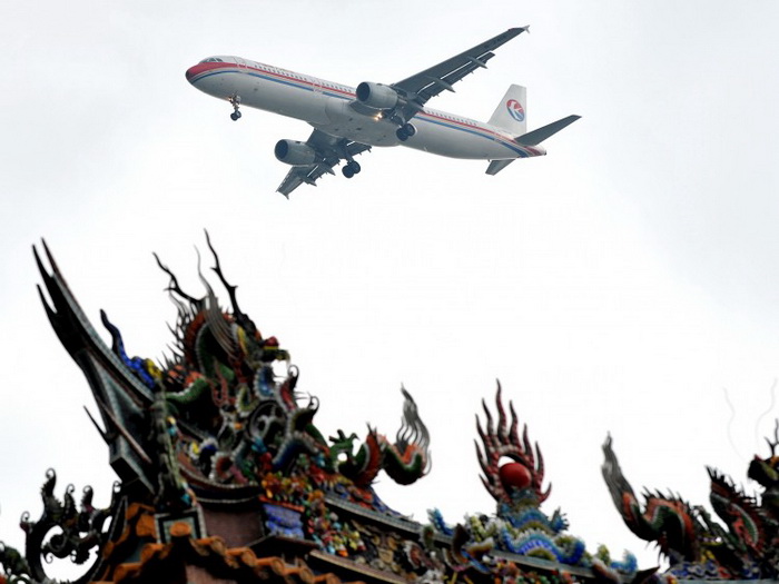 Самолёт авиакомпании China Eastern Airlines пролетает над храмом перед посадкой в Тайбэе 29 июня 2010 года. Цзэн Цинхун с 2002 года отмывал деньги через эту авиакомпанию. Фото: Patrick Lin/AFP/Getty Images   