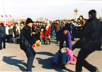 Полицейские агенты арестовывают сторонницу Фалуньгун, открыто выражающую протест против преследования со стороны коммунистического режима. Пекин. Фото: minghui.org