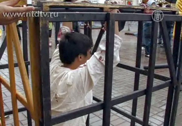 Ли во время инсценировки одного из видов пыток, которым в Китае подвергают сторонников Фалуньгун. Киев. Украина. Фото: NTD TV