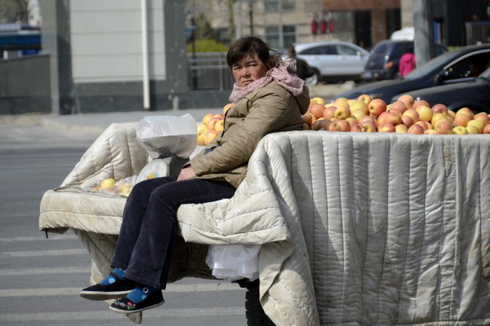 Торговка яблоками в Пекине, 14 апреля 2013 года. Уличных торговцев преследуют специальные службы, нанимаемые властями для обеспечения муниципальных нормативных актов. Фото: Wang Zhao/AFP/Getty Images