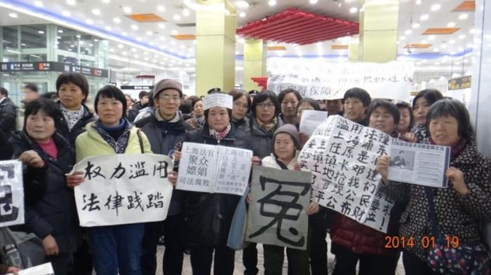 Протестующие держат плакаты в Экспоцентре в Шанхае, где проходит ежегодная парламентская сессия. 19 января 2014 г. Фото предоставлено апеллянтами