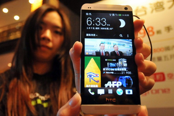 Девушка с новым смартфоном HTC, Тайбэй, 7 марта 2013 года. Фото: Mandy Cheng/AFP/Getty Images