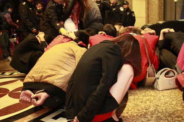 Полицейские окружили проституток и их клиентов в центре развлечений в южно-китайском городе Дунгуане 9 февраля 2014 г. Полицейские рейды были организованы после того, как центральное телевидение Китая  (CCTV) показало передачу, где рассказывалось, что в десятках отелей Дунгуаня предлагают секс-услуги. Фото: STR/AFP/Getty Images