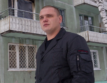 Томский таксист Александр Оконечников у дома 31 на улице Интернационалистов рассказывает о том, как он помог четверым детям спуститься через окно со второго этажа, когда в их квартире начался пожар. Фото РИА Новости