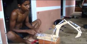 Уэсли играет с самодельным экскаватором. Фото сделано из YouTobe.