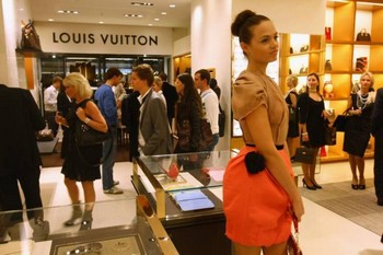 Модель приветствует прохожих, делающих покупки в магазине-люкс Louis Vuitton в Берлине. Богатые становятся все богаче за счет бедных, говорят циники. Фото: Sean Gallup /Getty Images