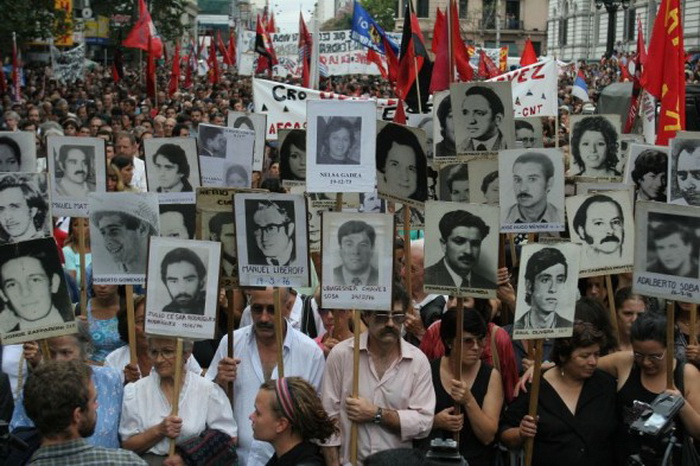 Во время протестов 14 марта 2006 г. в Монтевидео в Уругвае люди держат плакаты пропавших без вести во времена военной диктатуры, которая продолжалась в стране с 1973 г. по 1985 г.г. Пианист Мигель Анхель Эстрелла в то время подвергся пыткам, инициированным врачом-психологом. Фото: Pablo Porciuncula/AFP/Getty Images