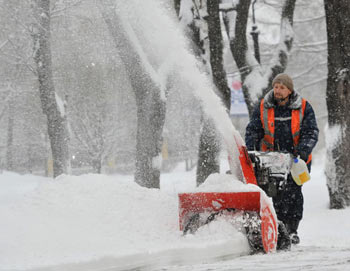Сотрудник коммунальных служб убирает снег на одной из улиц города. Фото РИА Новости