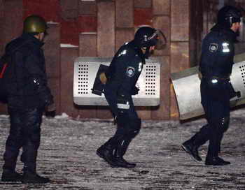  Милиционеры покидают здание Украинского дома на Европейской площади. Фото: SERGEI SUPINSKY/AFP/Getty Images 