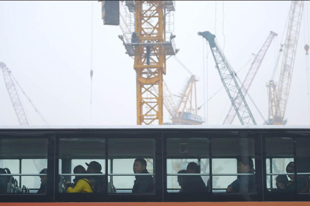 Автобус проезжает мимо стройки в Пекине 20 ноября 2014 года. Фото: WANG ZHAO/AFP/Getty Images
