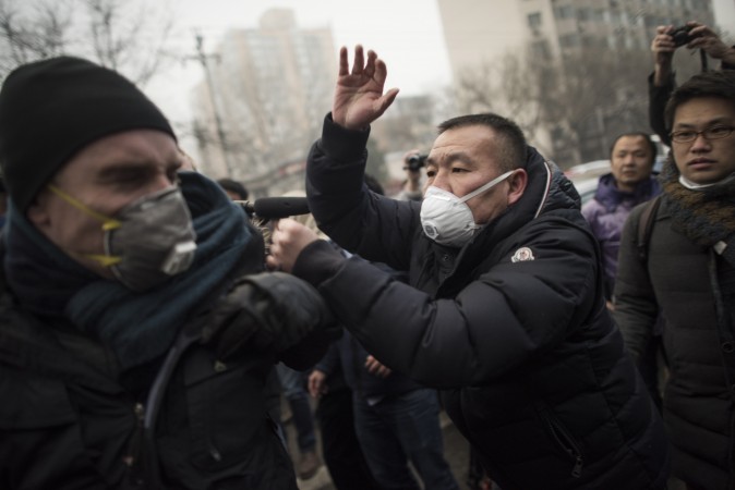 Китайская милиция растолкала и швырнула на землю журналистов и протестующих, собравшихся у здания пекинского суда перед процессом над известным адвокатом Пу Чжицяном 14 декабря 2015 г. Фото: Fred Dufour/AFP/Getty Images