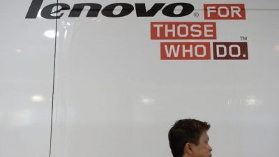 Мужчина проходит мимо рекламы Lenovo в компьютерном центре в Гонконге, 14 августа 2014 г. (Dale de la Rey / AFP / Getty Images)