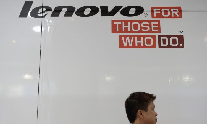 Мужчина проходит мимо рекламы Lenovo в компьютерном центре в Гонконге, 14 августа 2014 г. (Dale de la Rey / AFP / Getty Images)