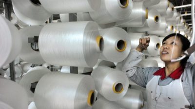 Китайский рабочий проверяет машину для производства одеял на экспорт на фабрике в Иу, провинция Чжэцзян, 12 января. (STR / AFP / Getty Images)