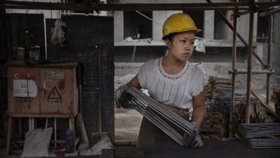 Китайская женщина-строитель работает на строительной площадке нового жилого комплекса в Пекине 29 августа 2014 г. (Кевин Фрайер / Getty Images)