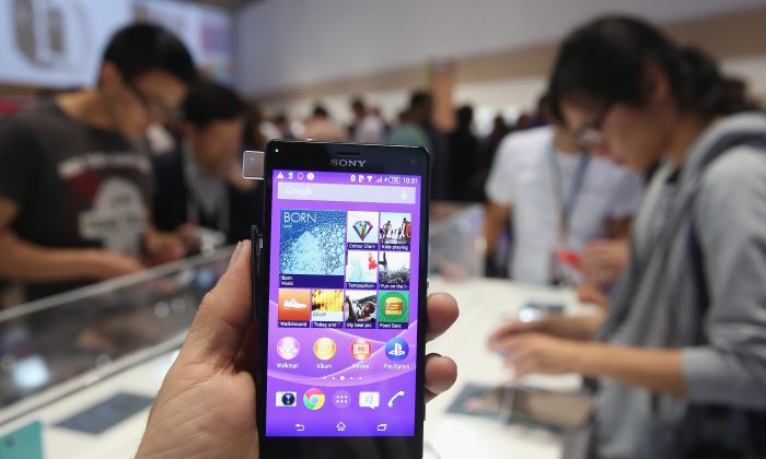 Фотограф держит смартфон Sony Xperia Z3 в Берлине, Германия. В смартфонах обнаружен зараженный файл, передающий данные в Китай. (Шон Гэллап / Getty Images)