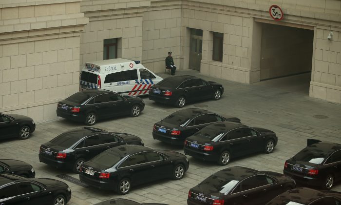 Солдат охраняет машины высших руководителей в Большом зале народных собраний во время собрания Всекитайского собрания народных представителей 8 марта 2013 года в Пекине, Китай. 16 июля Китай официально обнародовал программу реформ по сокращению использования государственными органами автомобилей, предоставленных государством. (Фэн Ли / Getty Images)