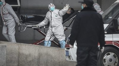 Медицинский персонал переводит пациента в больницу «Цзинь Иньтан» в Ухане, Китай, 17 января 2020 года. Getty Images