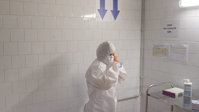 Медицинский работник надевает средства индивидуальной защиты (СИЗ) перед входом в полевой Госпиталь дель Мар, Барселона, Испания, 10 апреля 2020 года. David Ramos/Getty Images