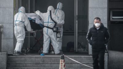 Медицинский персонал доставляет пациента в больницу Цзиньинтань в Ухане, 18 января 2020 года. STR/AFP via Getty Images