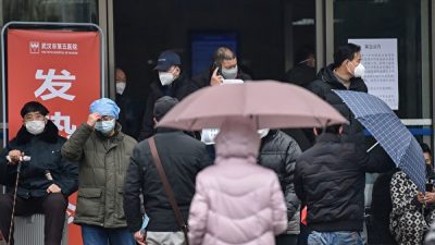 Люди в масках выходят из здания Пятой больницы города Ухань, провинция Хубэй, Китай, 24 января 2020 года. HECTOR RETAMAL/AFP via Getty Images