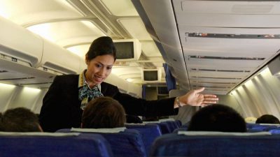 Стюардесса компании Garuda Indonesia помогает пассажиру во время полета из Паданга в Джакарту. (Адек БерриAFP / Getty Images)
