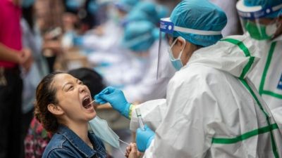 Медицинский работник берёт образец у жителя Уханя для тестирования на COVID-19, Китай, 15 мая 2020 года. STR / AFP через Getty Images