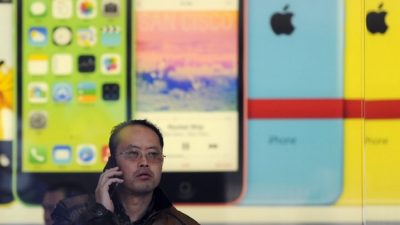 Китаец звонит по мобильному телефону в магазине Apple в Пекине 17 января 2014 года.  Фото: WANG ZHAO/AFP/Getty Images