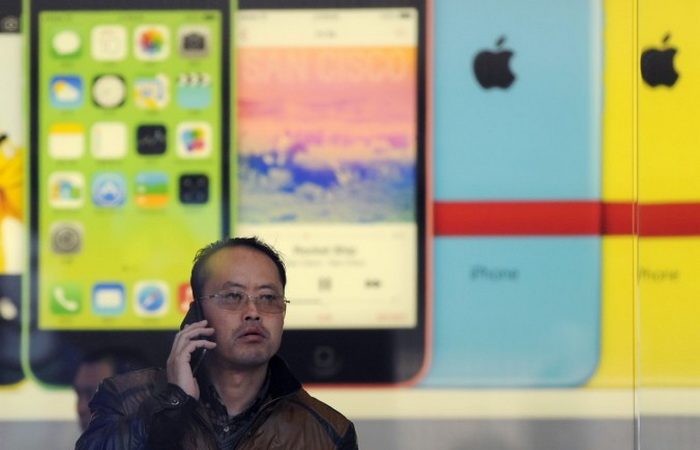 Китаец звонит по мобильному телефону в магазине Apple в Пекине 17 января 2014 года.  Фото: WANG ZHAO/AFP/Getty Images