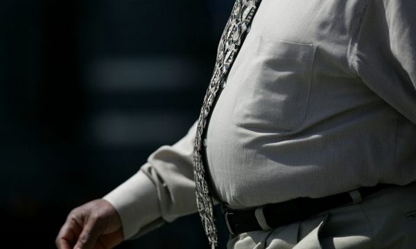 Полный мужчина идет по набережной Эмбаркадеро в Сан-Франциско
