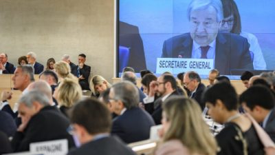 Генеральный секретарь ООН Антониу Гутерриш (на экране) выступает на открытии ежегодной сессии Совета ООН по правам человека в Женеве, 24 февраля 2020 года. FABRICE COFFRINI/AFP via Getty Images