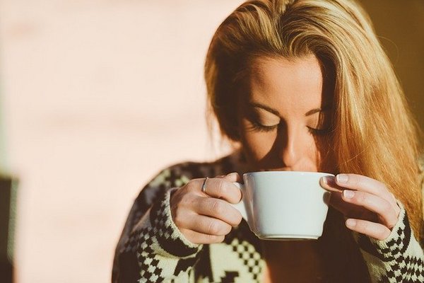 Девушка держит чашку двумя руками