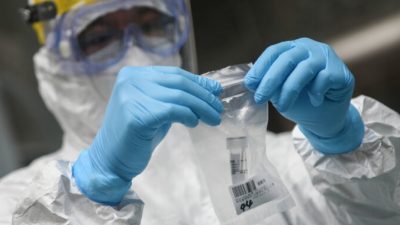 Медицинский работник собирает образцы для тестирования COVID-19 в средней школе в Гуанчжоу, Китай, 21 апреля 2020 года. STR/AFP via Getty Images