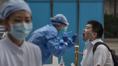 Медицинский работник проводит тест на нуклеиновую кислоту у журналиста, освещающего  Всекитайское собрание народных представителей в Пекине, Китай, 28 мая 2020 года. Kevin Frayer/Getty Images