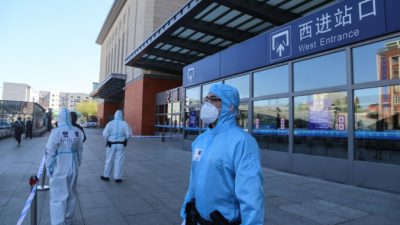 Полицейские стоят на страже у железнодорожного вокзала города Цзилинь, закрытого из-за вспышки COVID-19 в Цзилине, Китай, 13 мая 2020 года.  STR/AFP via Getty Images 