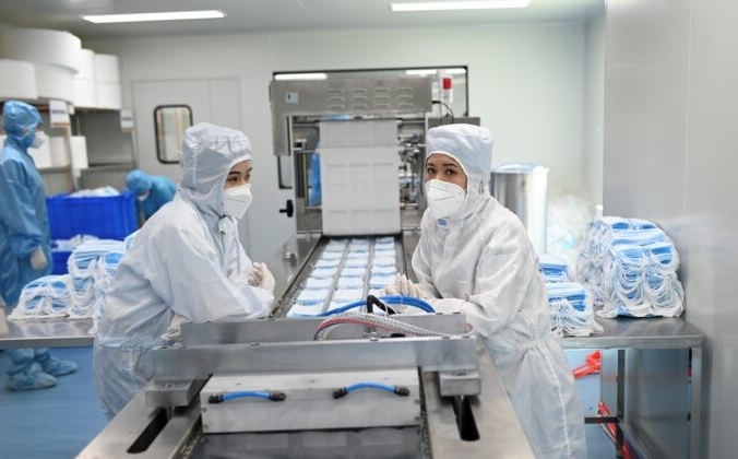 Две работницы готовятся к упаковке масок в  помещении Naton Medical Group в Пекине, Китай, 24 апреля 2020 года. WANG ZHAO/AFP via Getty Images