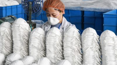 Работница изготавливает защитные маски на фабрике в городе Ханьдань, Китай, 28 февраля 2020 года. STR / AFP через Getty Images