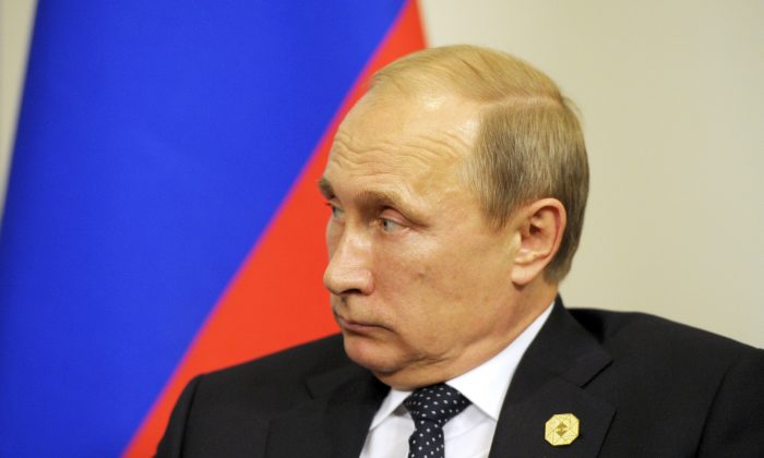 Президент России Владимир Путин смотрит на президента Франции во время их двусторонней встречи на полях саммита G20 в Брисбене, Австралия, в субботу, 15 ноября 2014 г. (AP Photo / Alain Jocard, Pool)