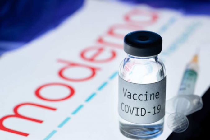 На снимке изображены шприц и флакон с надписью «Вакцина Covid-19» рядом с логотипом биотехнологической компании Moderna, 18 ноября 2020 года. JOEL SAGET/AFP via Getty Images