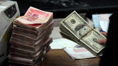 Работник китайского банка готовит пачки долларов и юаней, Хэбэй, провинция Аньхуэй, 9 марта 2010 года. Фото: STR/AFP/Getty Images