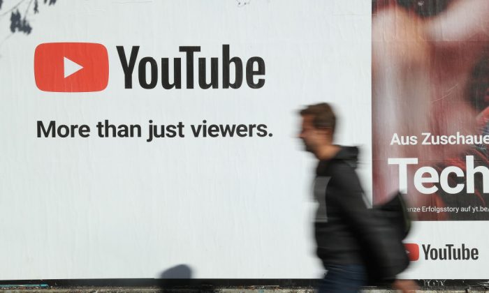 Мужчина проходит мимо рекламного щита YouTube в Берлине 5 октября 2018 года