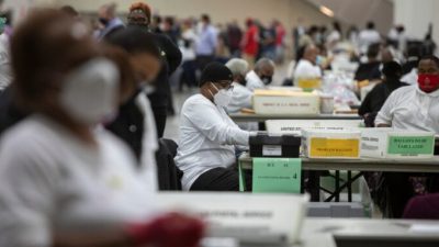 Роботник избирательного департамента Детройта помогает обрабатывать бюллетени для заочного голосования в Кобо-центр, Детройт, штат Мичиган, 4 ноября 2020 года. Elaine Cromie/Getty Images