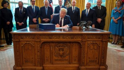 Президент Дональд Трамп подписывает в Овальном кабинете Белого дома закон CARES, пакет для оказания экономической помощи на сумму 2,2 триллиона долларов в условиях вспышки эпидемии 27 марта 2020 года. Jim Watson/AFP via Getty Images